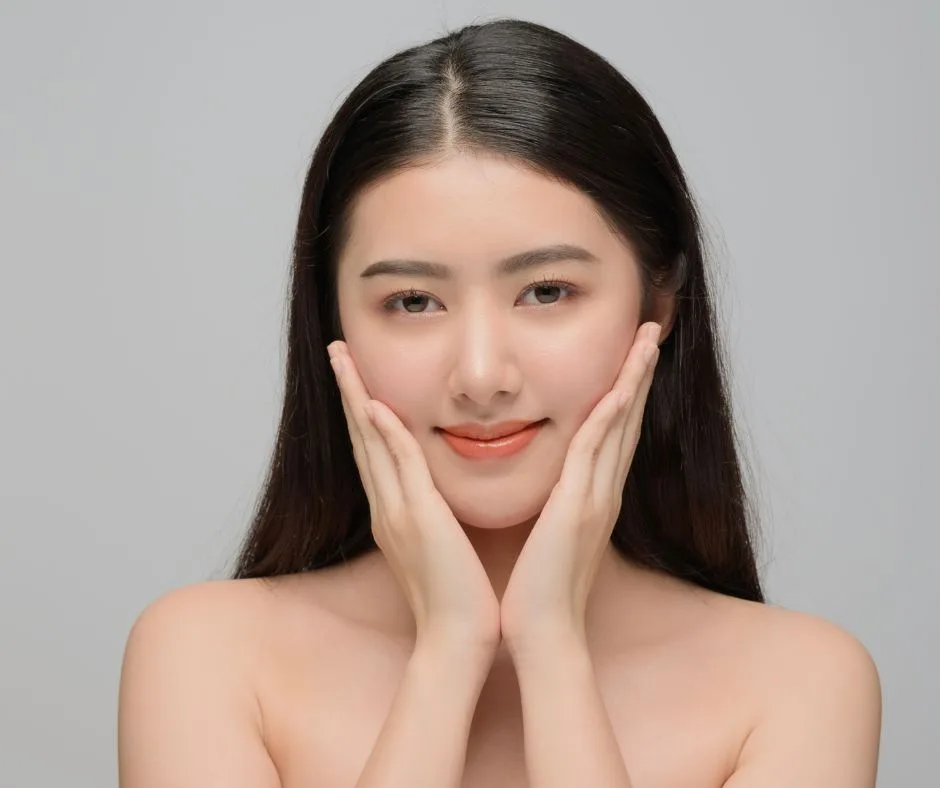Woman with smooth, hydrated skin gently cupping her face after using an anti-aging mask